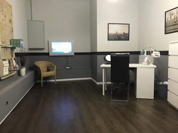 Modernes Kosmetikstudio mit Schreibtisch, Stuhl und stilvollem Interieur für Behandlungen.